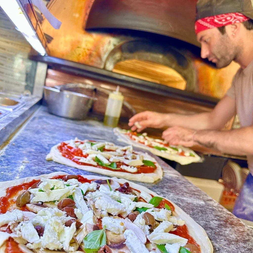 Garniture des pizzas au plan de travail en marbre